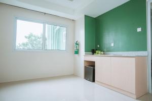 une cuisine avec un mur vert et une fenêtre dans l'établissement Diane Residences, à Mabolo