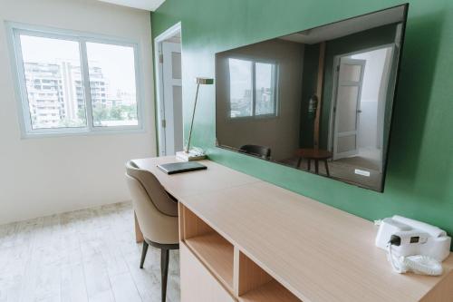 - un bureau avec un miroir sur un mur vert dans l'établissement Diane Residences, à Mabolo