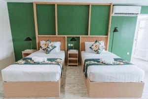- 2 lits dans une chambre aux murs verts dans l'établissement Diane Residences, à Mabolo
